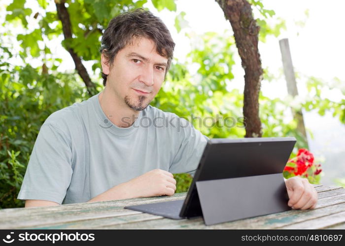 casual man working with a tablet pc, outdoor