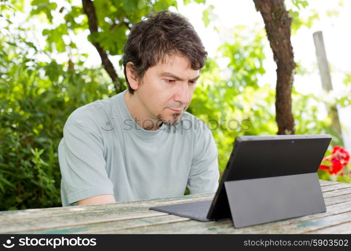 casual man working with a tablet pc, outdoor