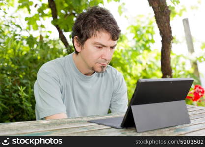 casual man working with a tablet pc, outdoor