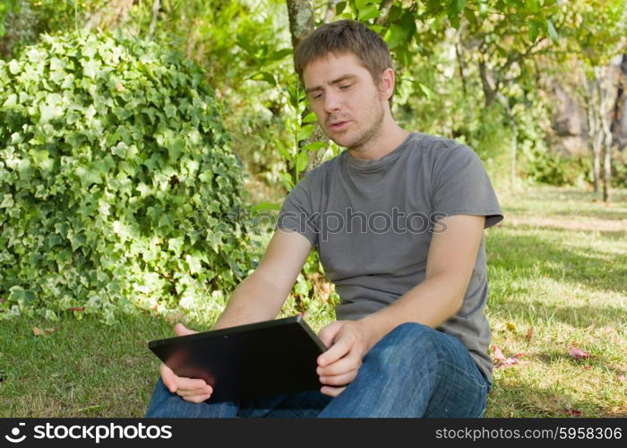 casual man working with a tablet pc, outdoor