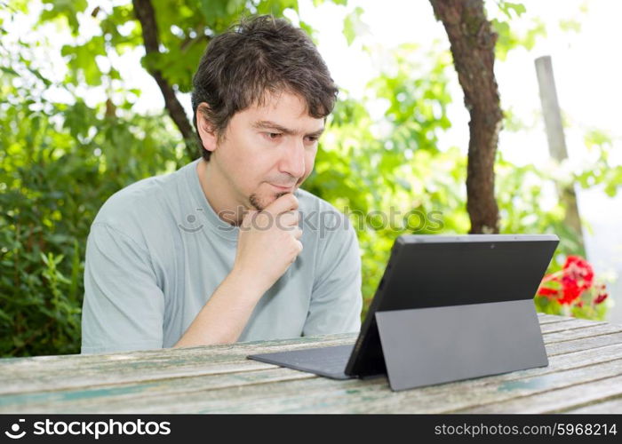 casual man working with a tablet pc, outdoor