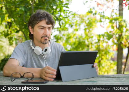 casual man working with a tablet pc, outdoor