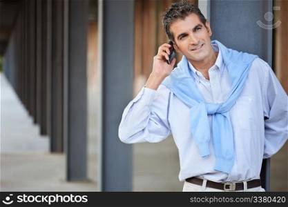 Casual smart man talking on the phone and looking away