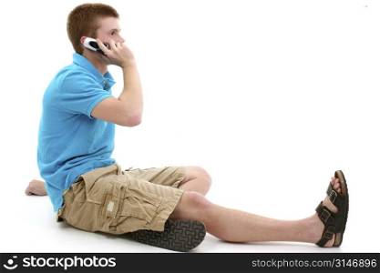 Casual teen boy sitting on talking on cellphone.