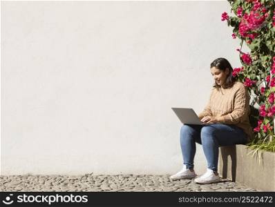 casual teenager browsing her laptop outdoors 3
