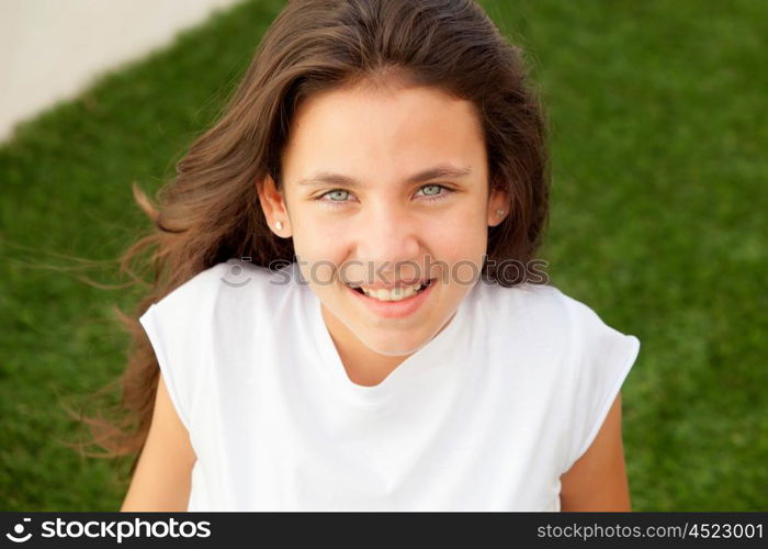 Casual teenager girl sitting on the grass outside