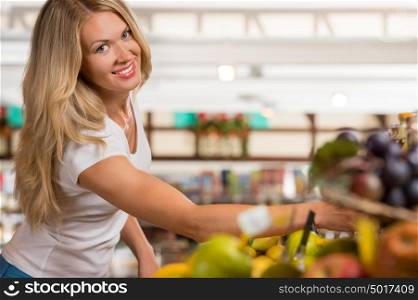 Casual woman grocery shopping at organic food section and looking happy at camera