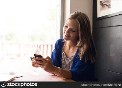 Casual woman using smartphone at coffee shop