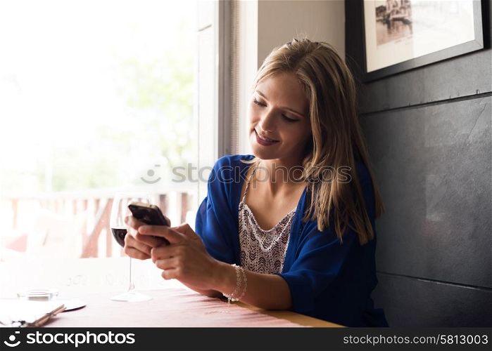 Casual woman using smartphone at coffee shop