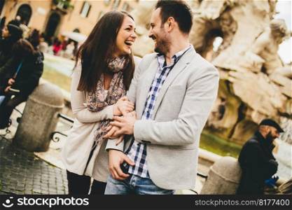 Casual young couple holding hands walking in Rome, Italy, Europe.