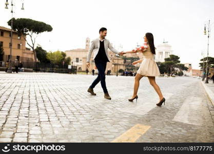 Casual young couple holding hands walking in Rome, Italy, Europe.