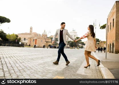 Casual young couple holding hands walking in Rome, Italy, Europe.