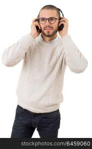 Casual young man listening music with headphones, isolated on white background