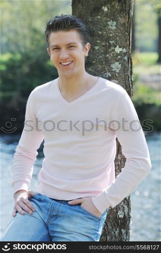 casual young man portrait waiting for date outdoor in nature at beautiful sunny spring day