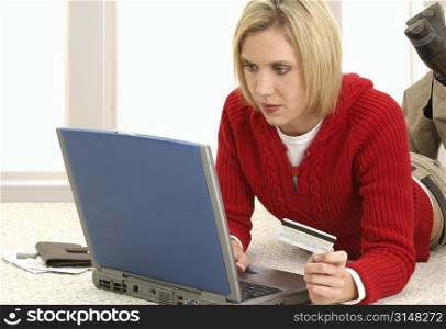 Casual young woman at home making online credit card payments.