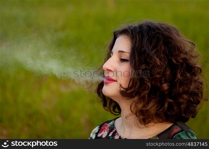 Casual young woman smoking a cigar in the landscape