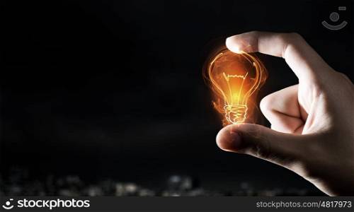 Catch bright idea. Male hand taking with fingers light bulb