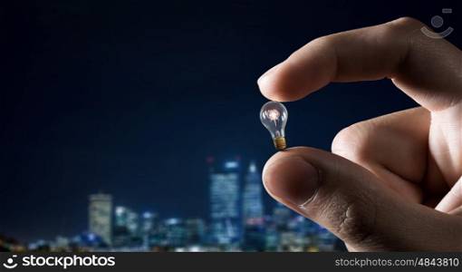 Catch bright idea. Male hand taking with fingers light bulb