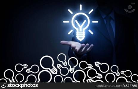 Catch bright idea. Young businessman holding glowing light bulb in palm