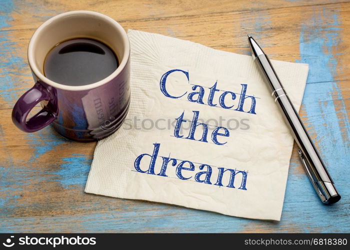 Catch the dream inspirational handwriting on a napkin with a cup of espresso coffee