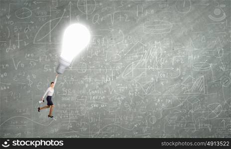 Catch your inspiration. Business woman is flying away on bright light bulb