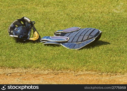 Catcher dress with mask over the grass of a baseball field