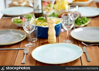 catering and eating concept - table served with plates, wine glasses and food. table served with plates, wine glasses and food