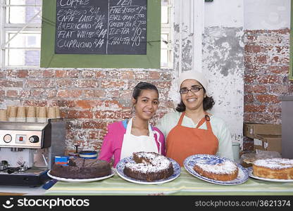 Catering assistants stand side by side in service area of canteen