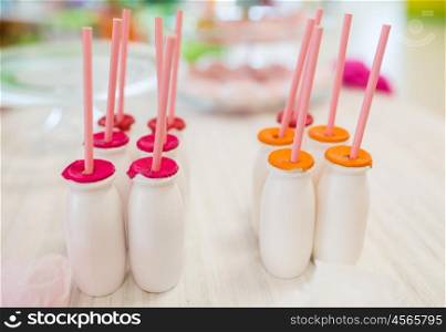 catering, serving and food concept - close up of bottles with drinks and straws on table