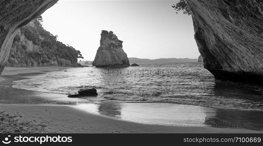 Cathedral Cove framed by arch on the beach, Coromandel, New Zealand.