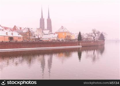Cathedral Island or Ostrow Tumski with with Cathedral of St. John and church of the Holy Cross and St. Bartholomew in the snowy overcast winter day in Wroclaw, Poland