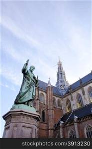 Cathedral St. Bavo with statue of printing inventor Laurens Janszoon Coster at big square Haarlem, The Netherlands