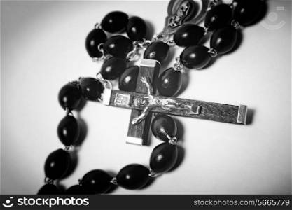 Catholic black wooden beads with metal crucifix on white background