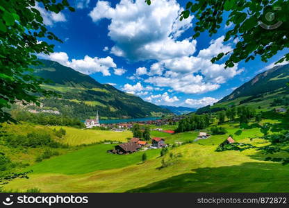 Catholic church, traditional wood and modern houses along the lake Lungernsee in swiss village Lungern, canton of Obwalden, Switzerland. Swiss village Lungern, Switzerland