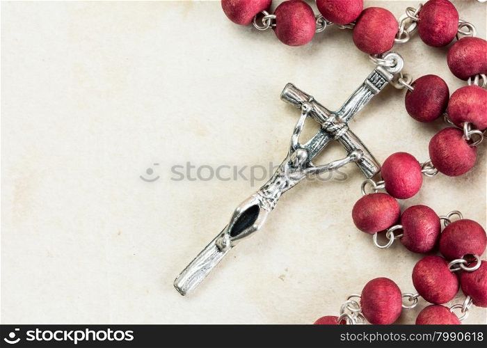 Catholic rosary on old paper background with copy-space
