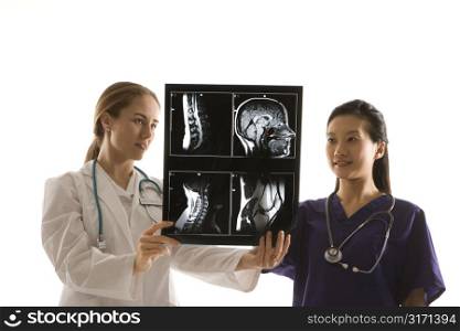 Caucasian and Asian Chinese mid-adult female doctors analyzing x-ray.