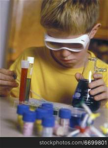 Caucasian Boy Doing Chemistry Experiment On Kitchen Table
