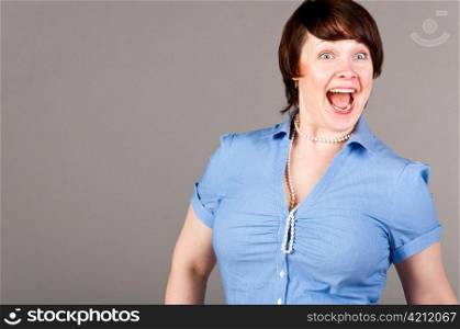 caucasian business woman is loudly screaming, on gray background