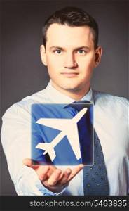 caucasian businessman is holding airplane icon in hands. business man with icon