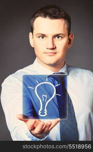 caucasian businessman is holding bulb in hands