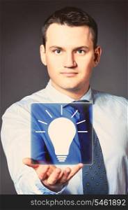 caucasian businessman is holding bulb in hands. business man with icon
