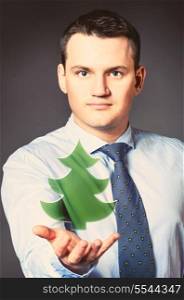 caucasian businessman is holding christmas tree in hands. business man with icon