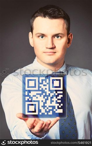 caucasian businessman is holding qr code in hands. business man with icon