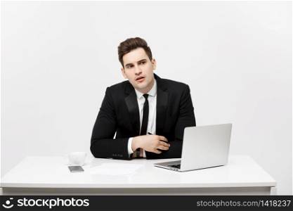 caucasian businessman sitting at desk looking and thinking in office. caucasian businessman sitting at desk looking and thinking in office.
