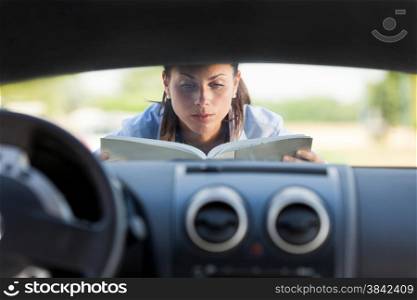 Caucasian businesswoman has a car problem and reads a car instruction