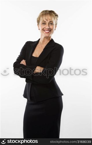 Caucasian businesswoman standing with arms crossed smiling at viewer.