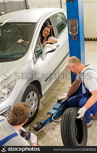 Caucasian car salesman changing tire in garage