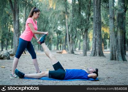 Caucasian couple doing stretching exercises in a park