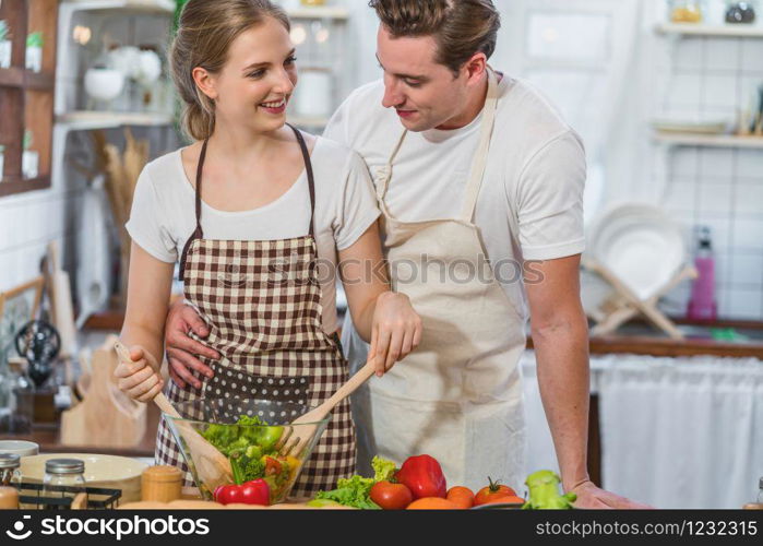 Caucasian couple or lovers cooking the breakfast with vegetables salad together in kitchen,just married and sweet honeymoon,relationship and healthcare,video social network,vlog and Influencer concept