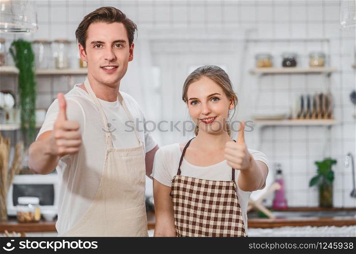 Caucasian couple or lovers doing Like action when taking photo or selfie when cooking breakfast together in kitchen,just married and sweet honeymoon,video social network,vlog and Influencer concept